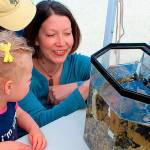 Kelly Zupich with Sound Water Stewards (right) explains to visitors at last years Penn Cove Water Festival how barnacles eat. Photo by Patricia Guthrie/Whidbey News-Times
