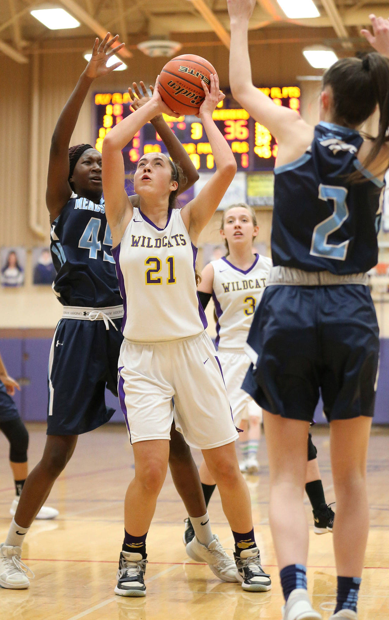 Oak Harbors Mikhaela Cortez splits the defense of Meadowdales Fatoumatga Jaiteh (45) and Taylor Kesselring (2). (Photo by John Fisken)