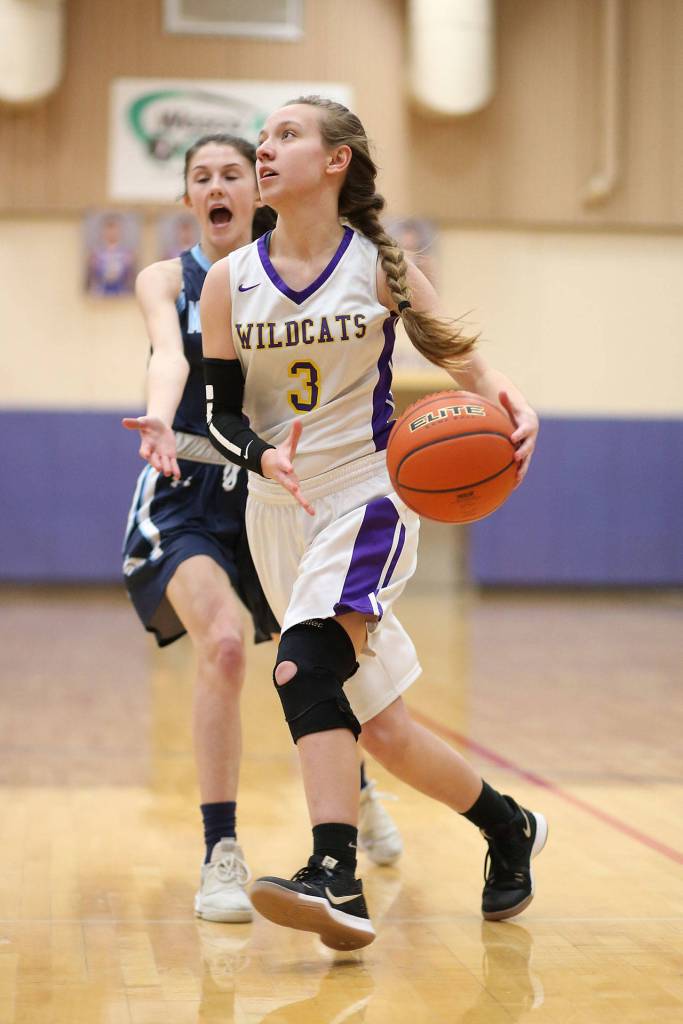 A Maverick defender yells for help as Oak Harbors Miranda Wilson (3) beats her to the basket.(Photo by John Fisken)