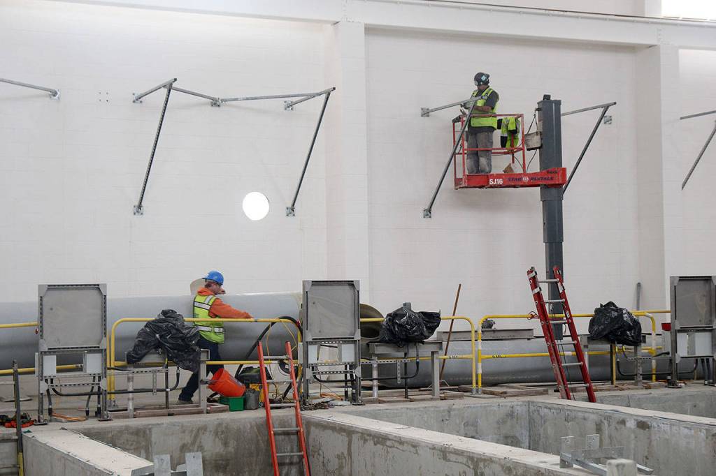 Photo by Jessie Stensland / Whidbey News-Times                                Members of a construction company work inside one of the buildings that makes up the sewage treatment plant being built in Oak Harbor