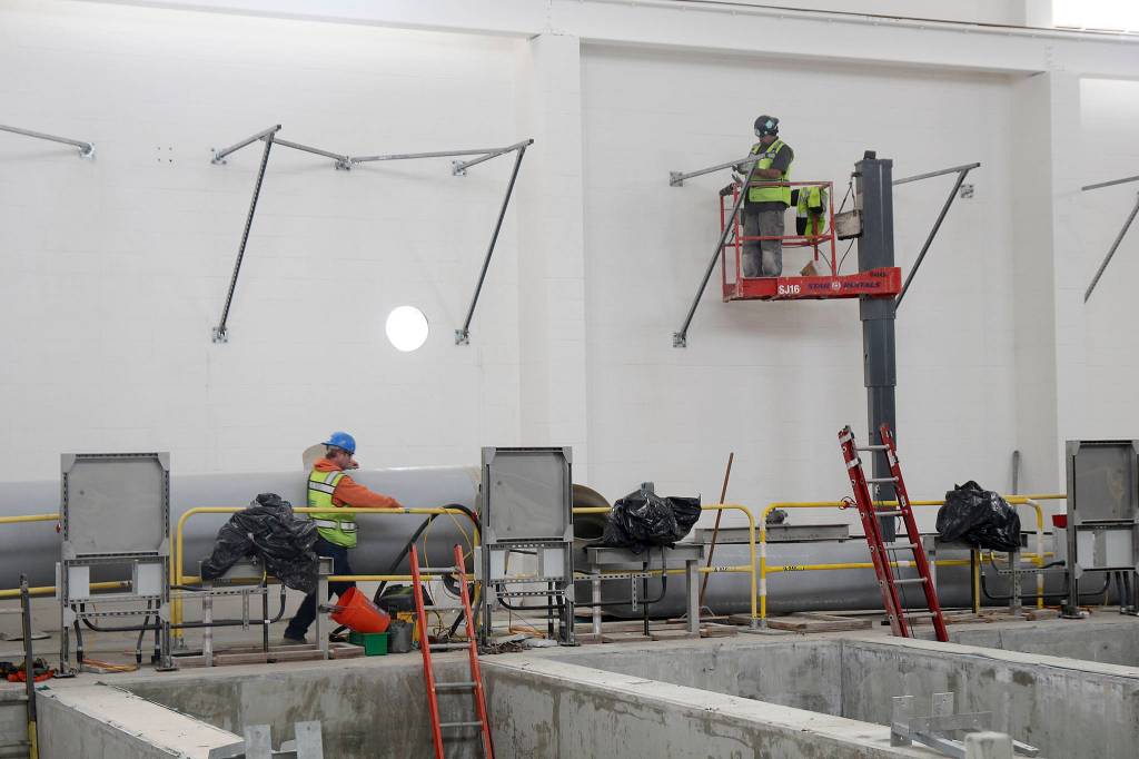 Photo by Jessie Stensland / Whidbey News-Times                                Members of a construction company work inside one of the buildings that makes up the sewage treatment plant being built in Oak Harbor