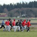 The Coupeville High School baseball team takes a lap around the field to get warmed up for the first day of practice Monday. (Photo by John Fisken)