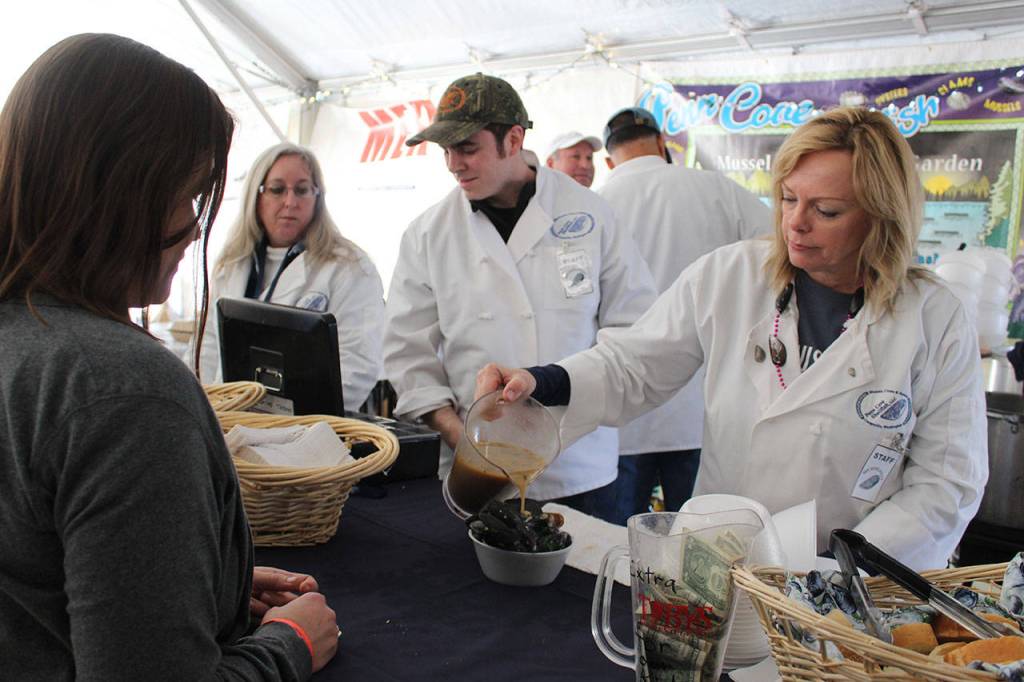 Deb Fanning (right) and Skip Dickinson (center) serve up heaping bowls of steamed mussels inside the company tent of Penn Cove Shellfish. It went through 1,000 pounds of the bold, briny blues in six hours.
