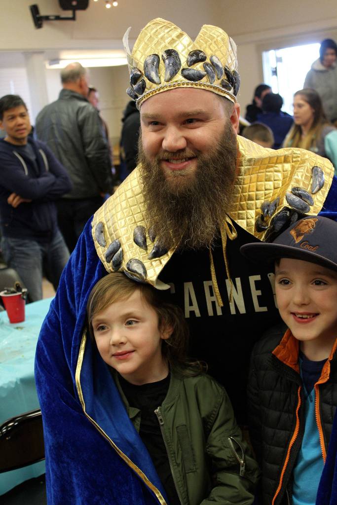 Ryan Leckie of Bellingham wears the cape and crown of Mussel Eating Champ for the second year in a row as he poses with his children, Kincaid and Gideon (right).