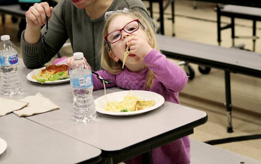 Photo by Laura Guido/Whidbey News-Times                                Reagan Olson, 3, chows down on her spaghetti Thursday night at Oak Harbor Elementary. Her family received a free dinner through the READY! for Kindergarten program, which aims to promote literacy, math and social skills in kids ages 0-5.