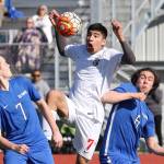 Coupevilles Aram Leyva Elenes splits to Olympic players to gain control of the ball. (Photo by John Fisken)