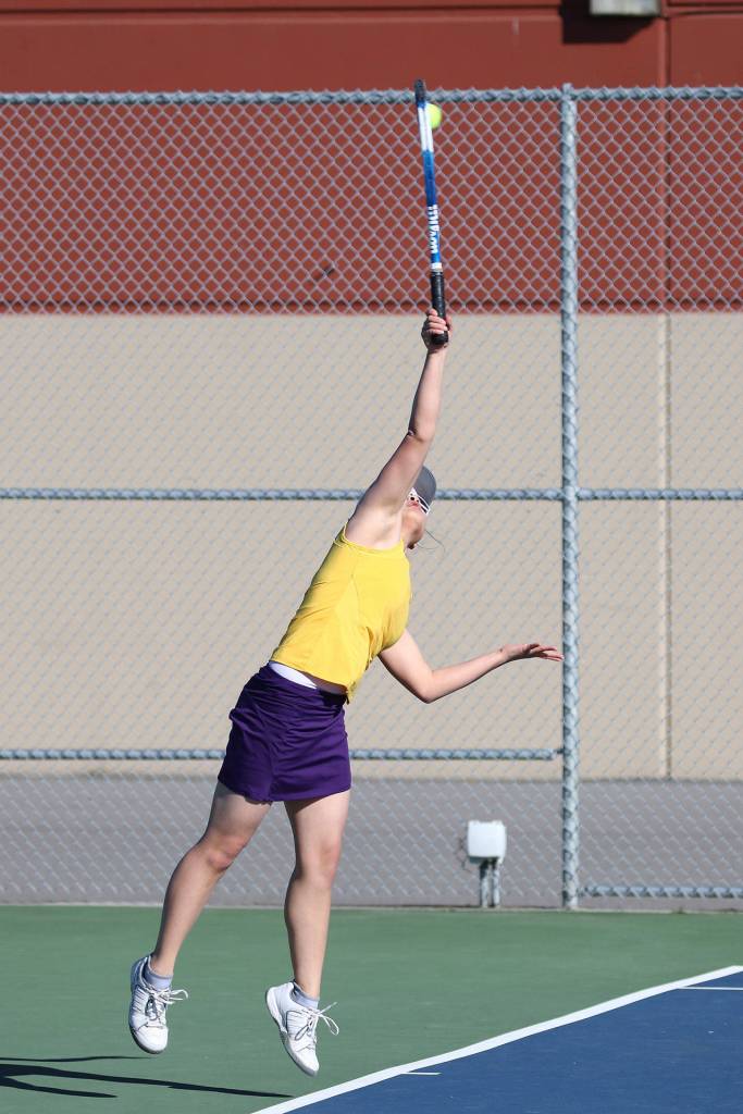 MJ Timm powers a serve in third singles. (Photo by John Fisken)