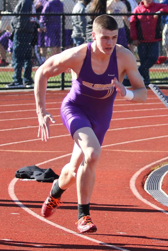 Cody Fenton runs the 100 meters for Oak Harbor. (Photo by John Fisken)