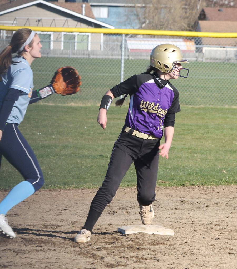 Oak Harbors Miranda Wilson rounds second base Friday while Everetts Megan Gordan checks the play at first base.(Photo by Jim Waller/Whidbey News-Times)