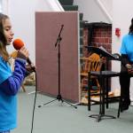 Katie Arguijo, 12, practices her song at Saturdays mentoring sessions for Whidbey Has Talent performers while Allenda Jenkins looks on.