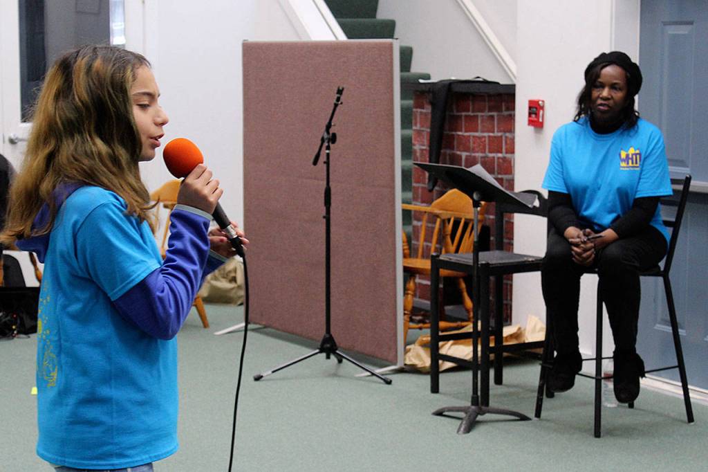 Katie Arguijo, 12, practices her song at Saturdays mentoring sessions for Whidbey Has Talent performers while Allenda Jenkins looks on.