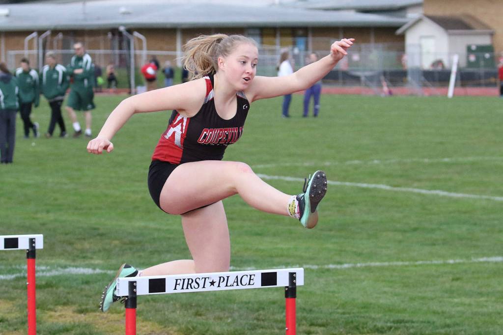 Mckenzie Meyer flies over a hurdle in the 300 meter race.(Photo by John Fisken)