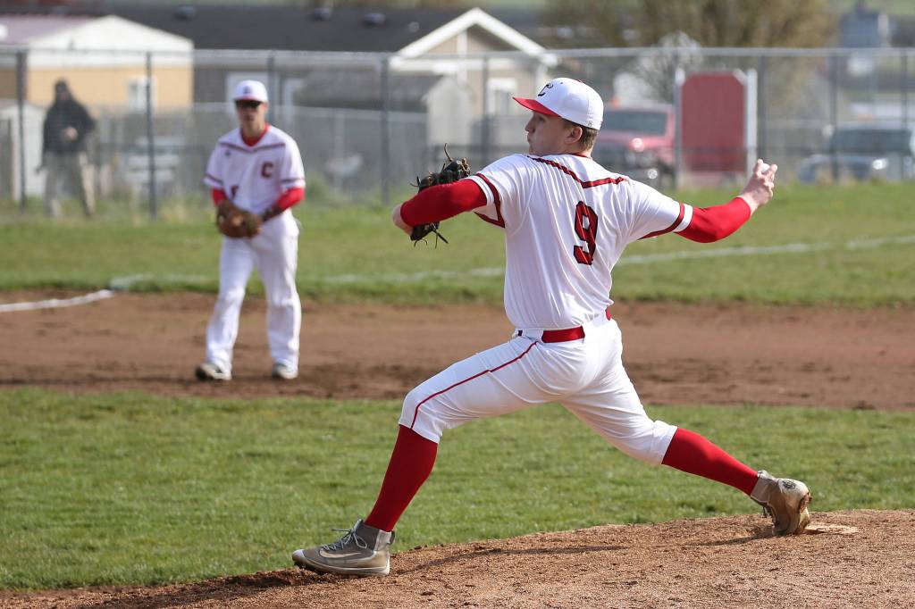 Dane Lucero tosses a pitch in Fridays game with Port Townsend. Lucero teamed with Matt Hiborn, playing third base in the background before taking over on the mound, for a one-hitter.(Photo by John Fisken)