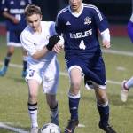 Oak Harbors Alexander Johnston (3) battles Arlingtons Evan Aune for possession.(Photo by John Fisken)