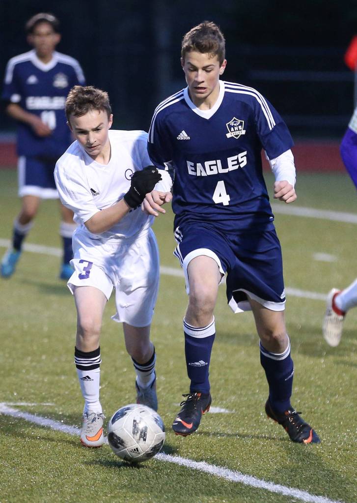 Oak Harbors Alexander Johnston (3) battles Arlingtons Evan Aune for possession.(Photo by John Fisken)