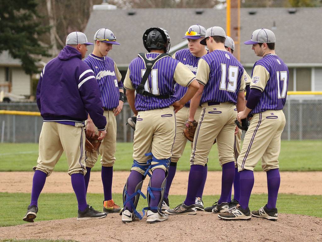 Oak Harbor coach Cody Anderson, left, meets with his team on the mound Tuesday.(Photo by John Fisken)