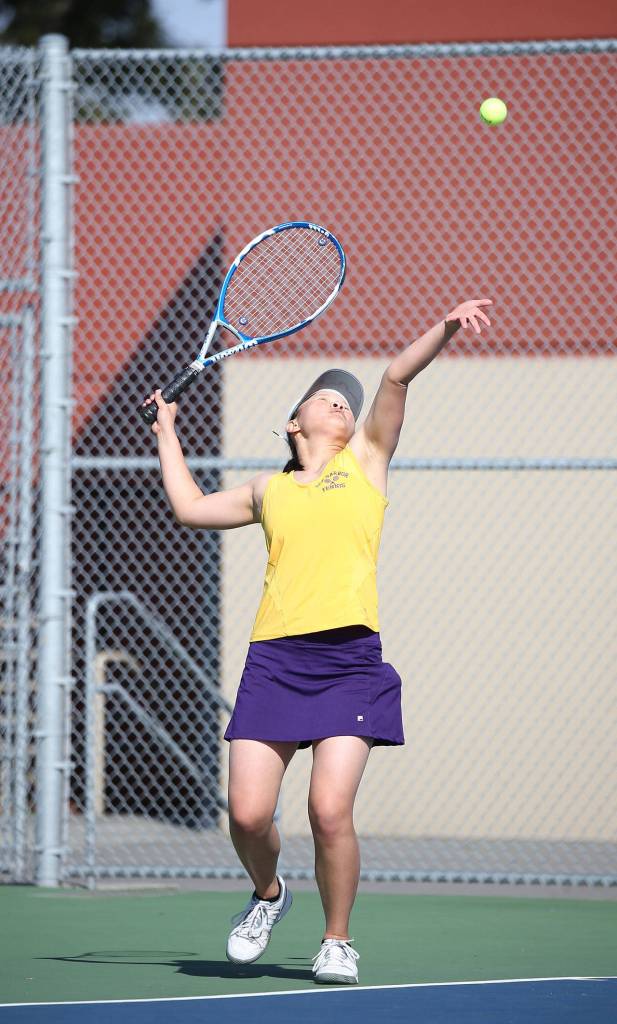 MJ Timm prepares to swat a serve in third singles.(Photo by John Fisken)