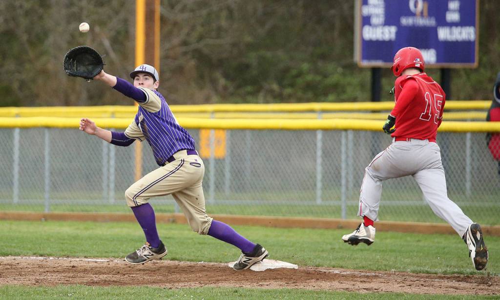 Oak Harbors James Besaw reaches for a throw as Stanwoods Levi Dahlberg races to first base.(Photo by John Fisken)