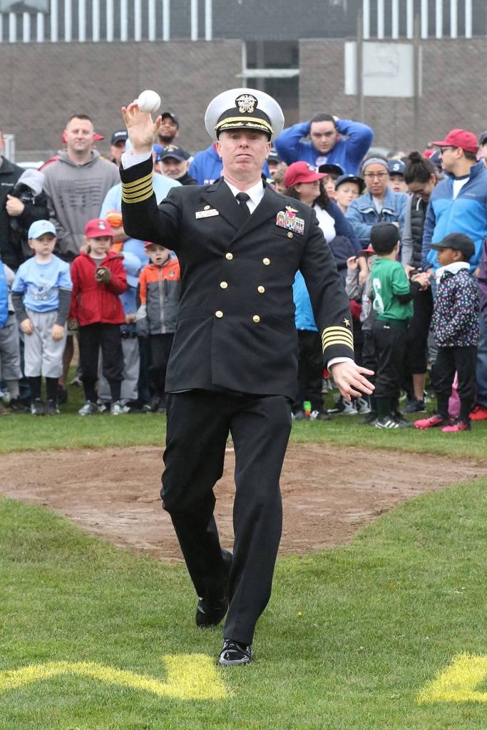 Captain Geoff Moore, Commanding Officer of NAS Whidbey, throws a ceremonial first pitch.(Photo by John Fisken)