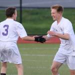 After scoring a goal, Nathan Merrill, center, is congratulated by teammate Alexander Johnston. (Photo by John Fisken)