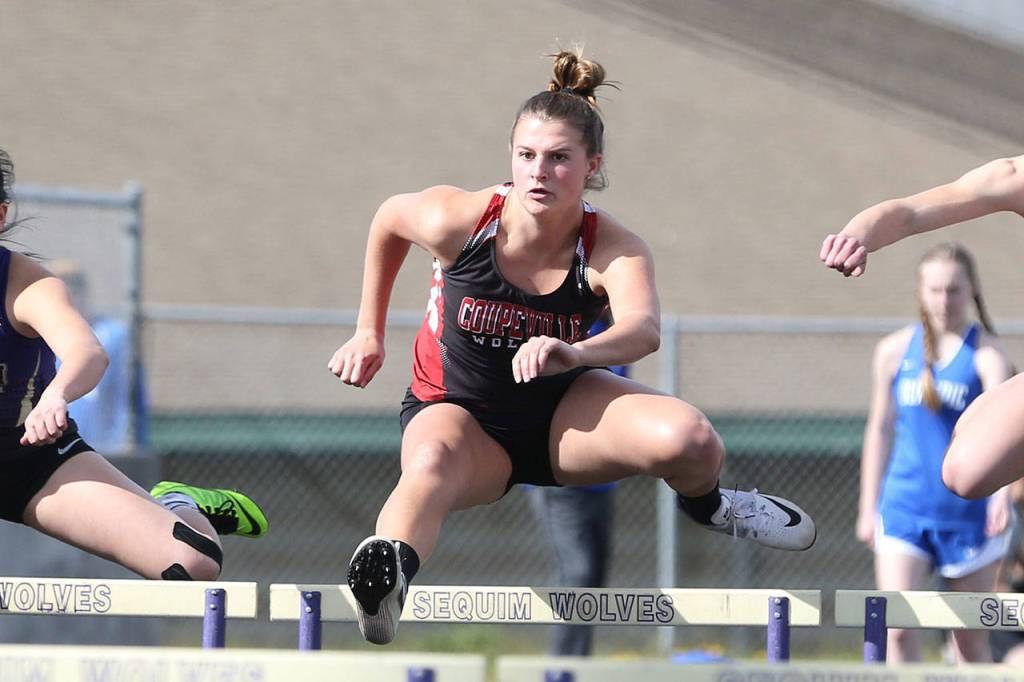 Lindsey Roberts skims over a hurdle on the way to winning the 100-meter event.(Photo by John Fisken)