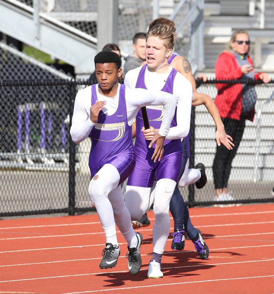 Andrew Miller, right, hands off to Dorian Hardin in Oak Harbors winning effort in the 4x100 relay.(Photo by John Fisken)