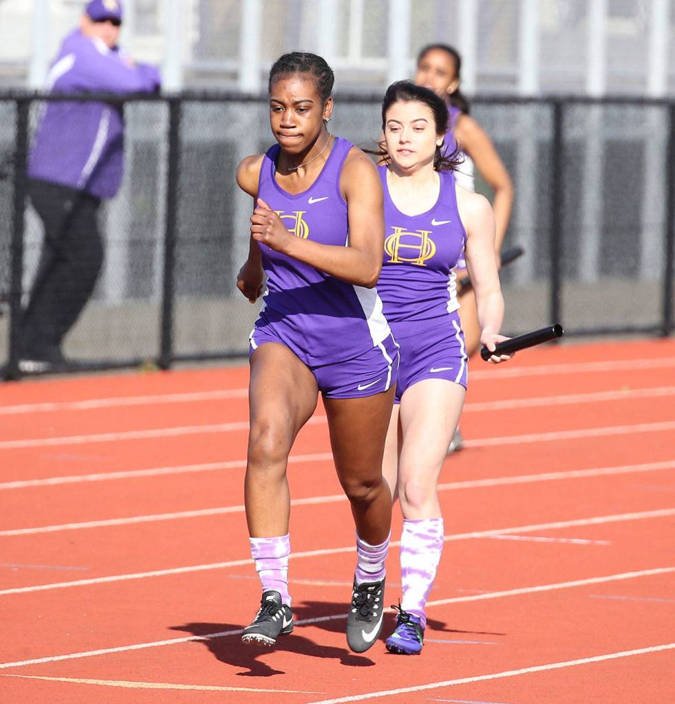 Kia Ceya, left, receives the baton from Alora Caillier in the 4x100 relay.(Photo by John Fisken)