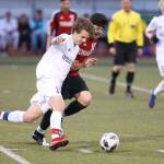 Eric Closson battles a Marysville-Pilchuck player for possession.(Photo by John Fisken)