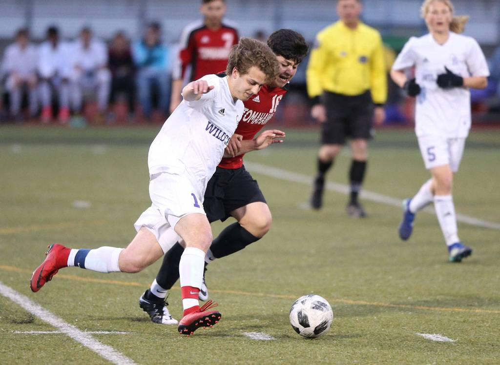 Eric Closson battles a Marysville-Pilchuck player for possession.(Photo by John Fisken)