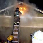 A firefighter from the Oak Harbor Fire Department vents the attic space during a structural fire around midnight on Monday. Photo provided