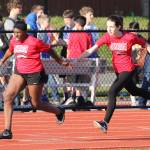 Anai Hardin, left, takes the baton from Alexis Kunze in the eighth-grade girls 4x100 relay Wednesday.(Photo by John Fisken)