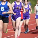 Alex Smith (second from left) runs the 3,200 Friday. Her sister Megan (background, purple jersey) also competed in the event. (Photo by John Fisken)