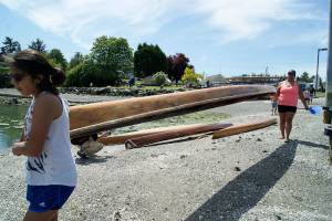 Photo by Maria Matson/Whidbey News-Times                                Janelle Solomon, 12, from the Lummi Nations Ultimate Warrior Canoe Club carries a canoe along with Regina Miller, who is about to participate in the Womans Singles races. See the story on page A9 of todays Whidbey News-Times.