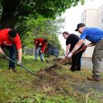 Jeff Green (left) David Zimmerman, Miranda Silverthorn, and James Philipsen (back left) work to uncover overgrown pathways in front of the old Whidbey News-Times builldings. Keller Williams employees and family members helped the Garage of Blessings with renovations of its new location last week. Photo by Laura Guido/Whidbey News-Times