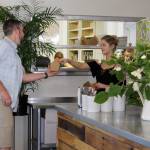 Lexi Parrick helps a customer in front of the new kitchens pick-up window. The cafe added some 1,200 square feet, including a full kitchen with a grill, oven and plenty of room to prep.