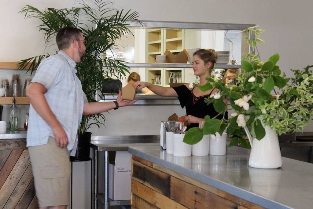 Lexi Parrick helps a customer in front of the new kitchens pick-up window. The cafe added some 1,200 square feet, including a full kitchen with a grill, oven and plenty of room to prep.