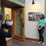 Lily Zustiak takes a photo of Chandell Schoonover in front of Consent, the work of art Schoonover submitted to the show Art with a Message, at the Bayview Cash Store Hub gallery.                                Photo by Patricia Guthrie/Whidbey News Group