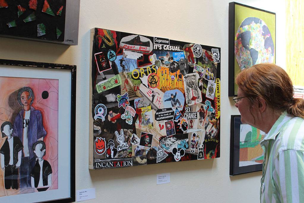 Marian Myszkowski, program and fund director of Goosefoot, looks over some of the pieces hanging on both floors of the Hub gallery in the Bayview Cash Store. The show is up until June 11.                                Photos by Patricia Guthrie/Whidbey News Group