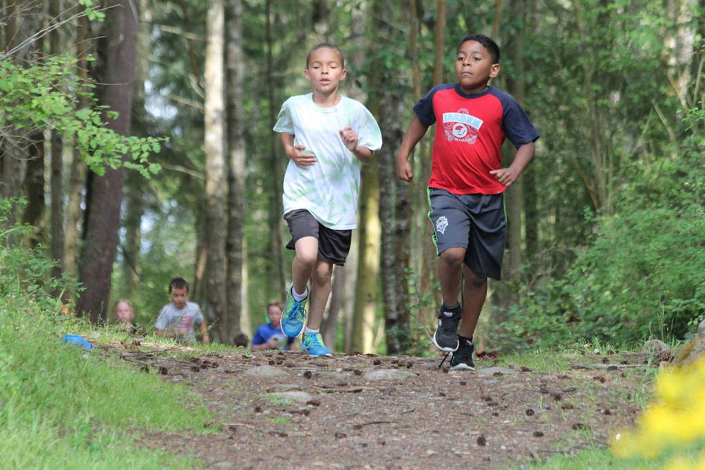 Crescent Harbor third-graders Sheldon Zabel, left, and Adam Garcia head down the path at Fort Nugent. (Photo by Jim Waller/Whidbey News-Times)