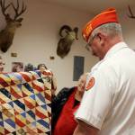 Frank Thorton receives a quilt from Anita Smith.
