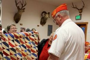 Frank Thorton receives a quilt from Anita Smith.
