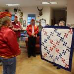 M. J. Margaret Johns receiving her quilt from Anita Smith.