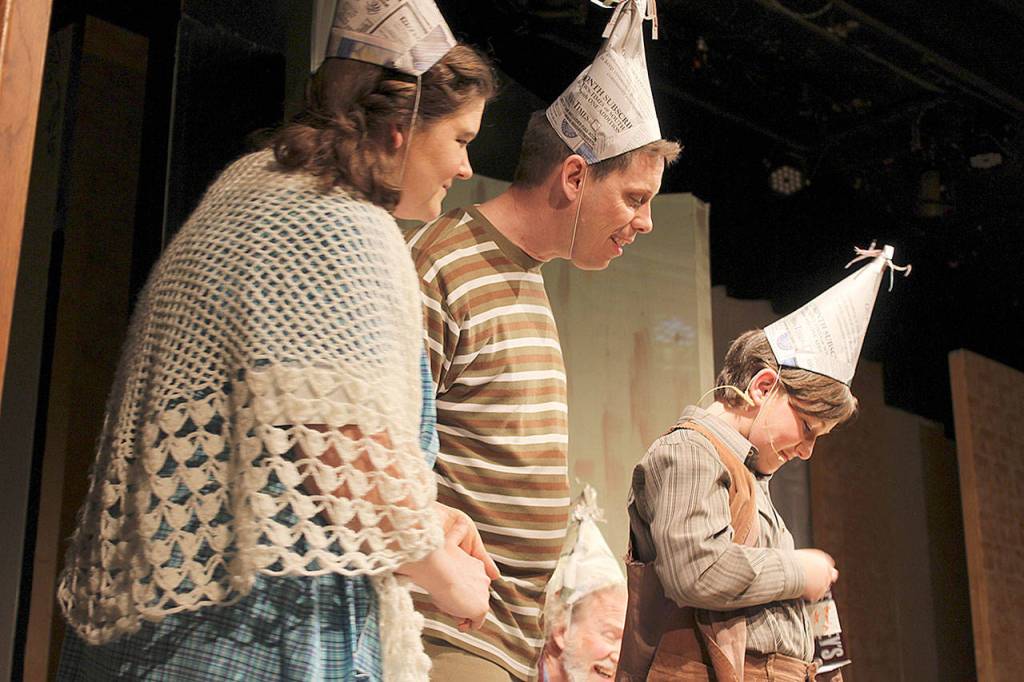 Mrs. and Mr. Bucket (Emily Nix and David Jackson) look on as Charlie Bucket (Maggie Garrett) opens up a candy bar looking for the golden ticket for a tour of Willy Wonkas chocolate factory.