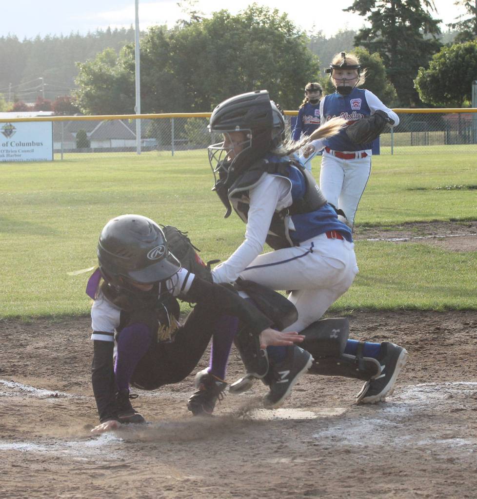 Olivia Aranguri-Plummer sneaks under the tag of Sedro-Woolley catcher Bryar Hart for a NW run. (Photo by Jim Waller/Whidbey News-Times)