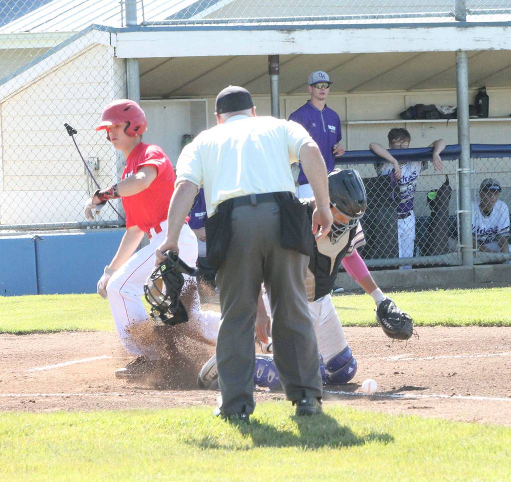 Coupevilles Matt Hilborn scores the games first run as Oak Harbor catcher Aaron Martinez knocks down a low throw to the plate.(Photo by Jim Waller/Whidbey News-Times)