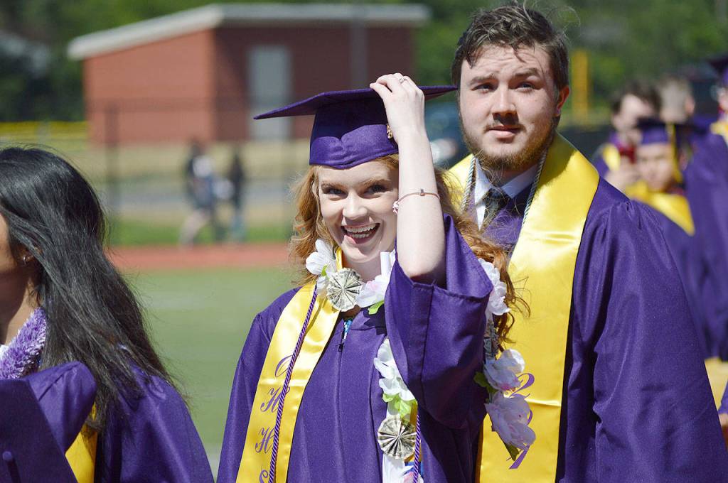 Makayla Emmie Hancock and Christopher Wyum walk toward the line of staff waiting to congratulate the class of 2018 after the commencement ceremony Saturday afternoon at Wildcat Memorial Stadium. Photo by Laura Guido/Whidbey News-Times