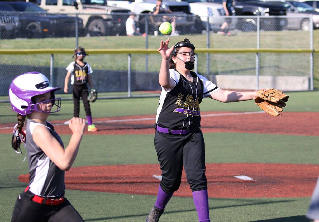 North Whidbey pitcher Katie Cantrell tosses to first base for an out.(Photo by John Fisken)