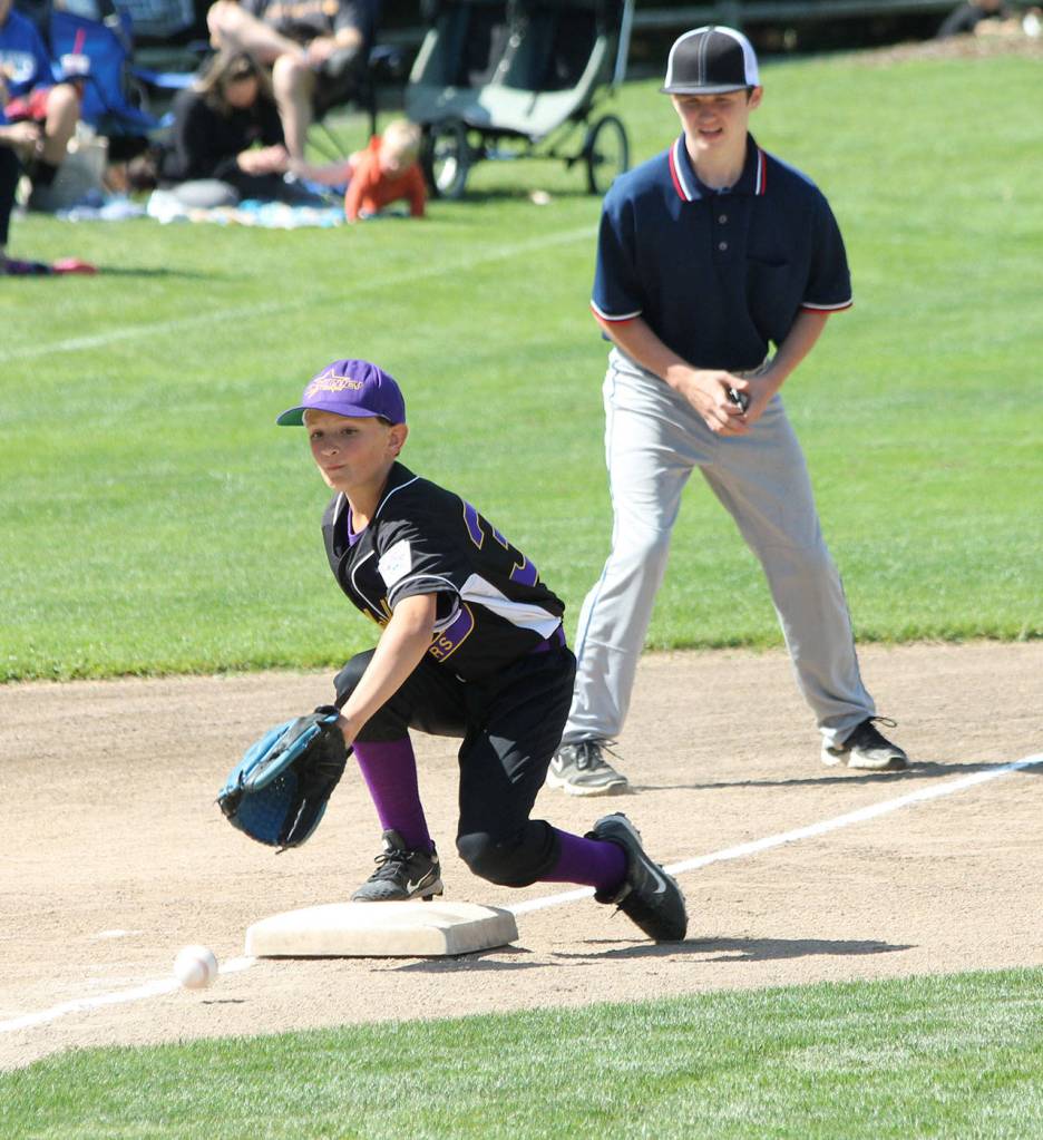 Third baseman Tristan Hamblin scoops up a low throw in an attempt to stop a Sedro-Woolley runner from advancing.(Photo by Jim Waller/Whidbey News-Times)