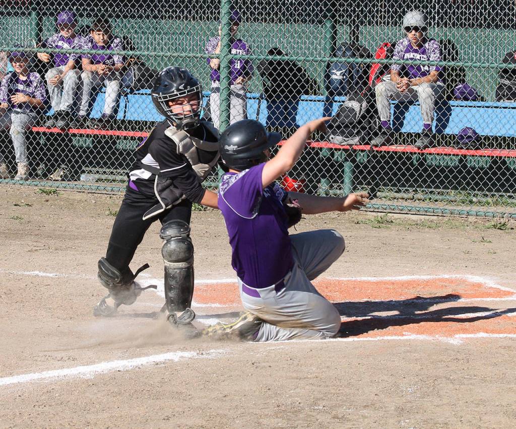 Catcher Kody Morrow slaps a tag on Anacortes Zack Decker trying to score on an over throw.(Photo by Jim Waller/Whidbey News-Times)