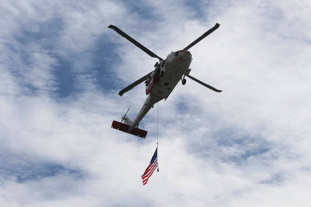 Photo by Jessie Stensland / Whidbey News-Times                                A search-and-rescue helicopter from Whidbey Island Naval Air Station flies overhead.